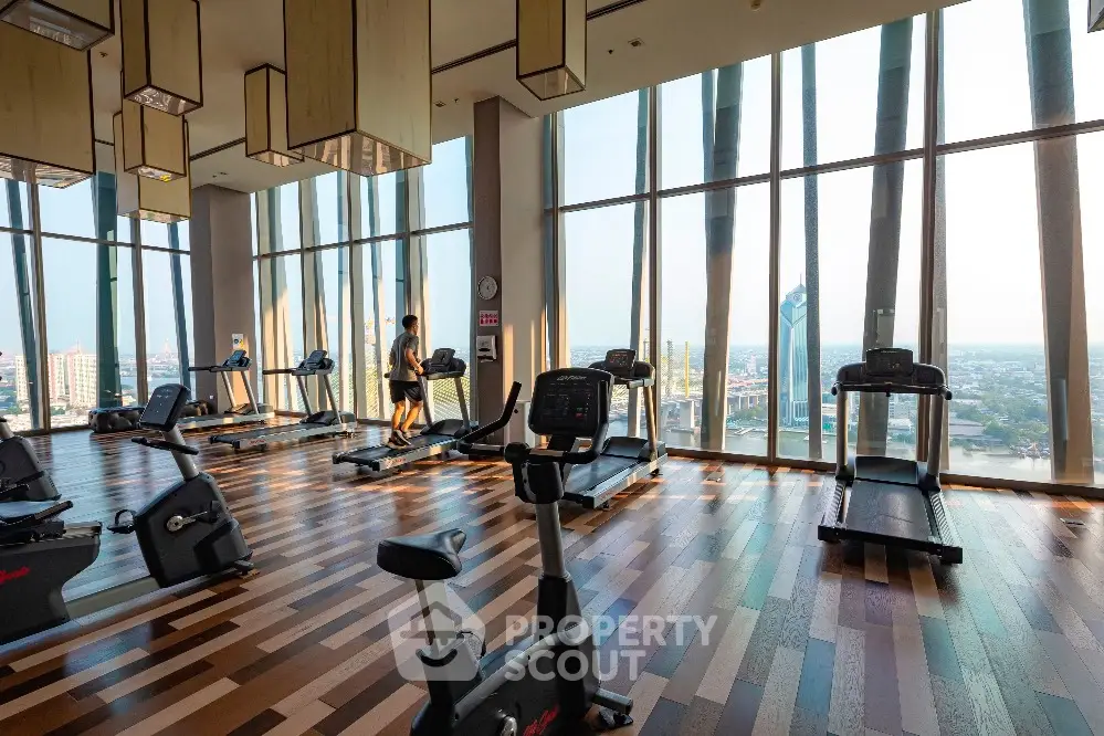Luxurious high-rise gym with panoramic city views and modern fitness equipment.