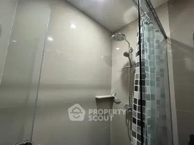 Modern bathroom with glass shower enclosure and stylish showerhead