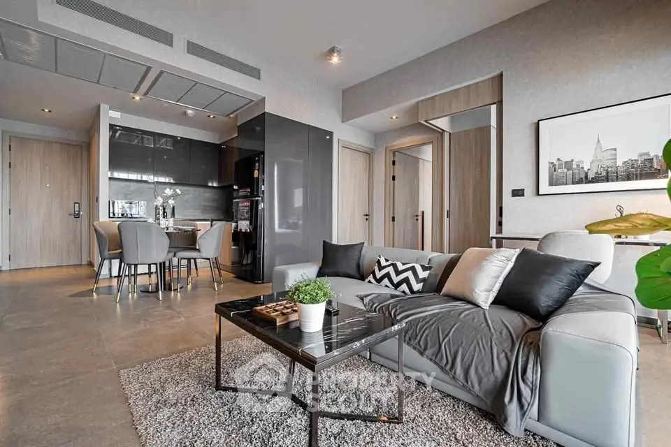 Modern living room with open kitchen, stylish decor, and cozy seating area in a contemporary apartment.