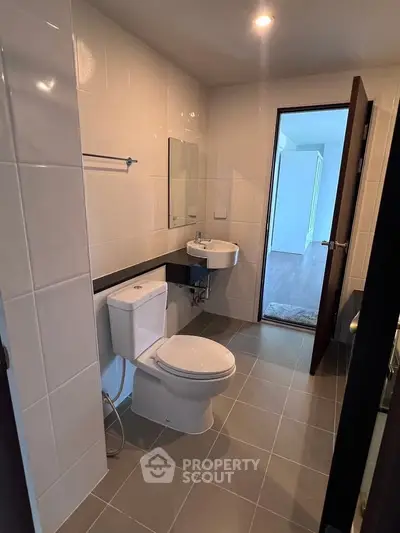 Modern bathroom with sleek fixtures and neutral tiles in a contemporary apartment.