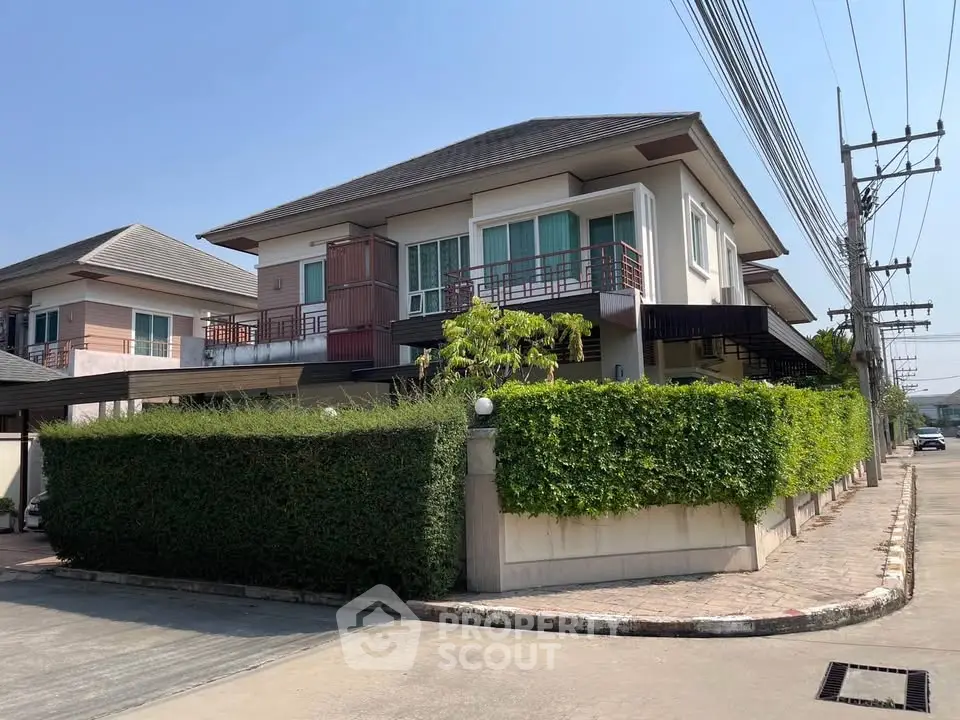 Modern two-story house with lush greenery and spacious driveway in a serene neighborhood.
