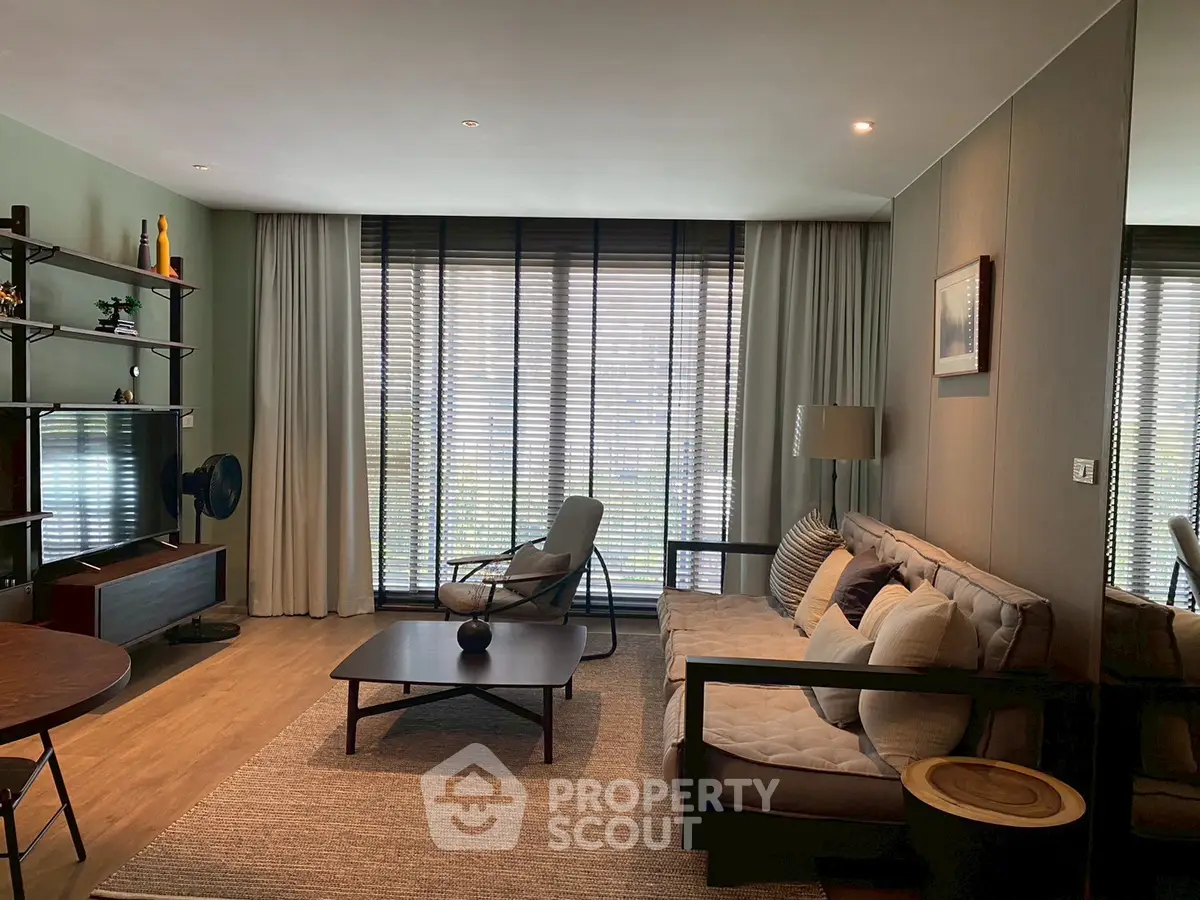 Stylish modern living room with cozy seating and large windows for natural light.