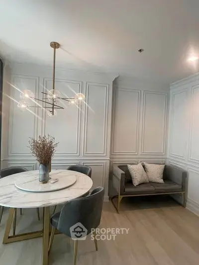 Elegant dining area with modern chandelier and stylish seating in a sophisticated interior design.