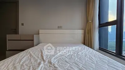 Modern bedroom with large window and city view, featuring minimalist furniture and neutral tones.