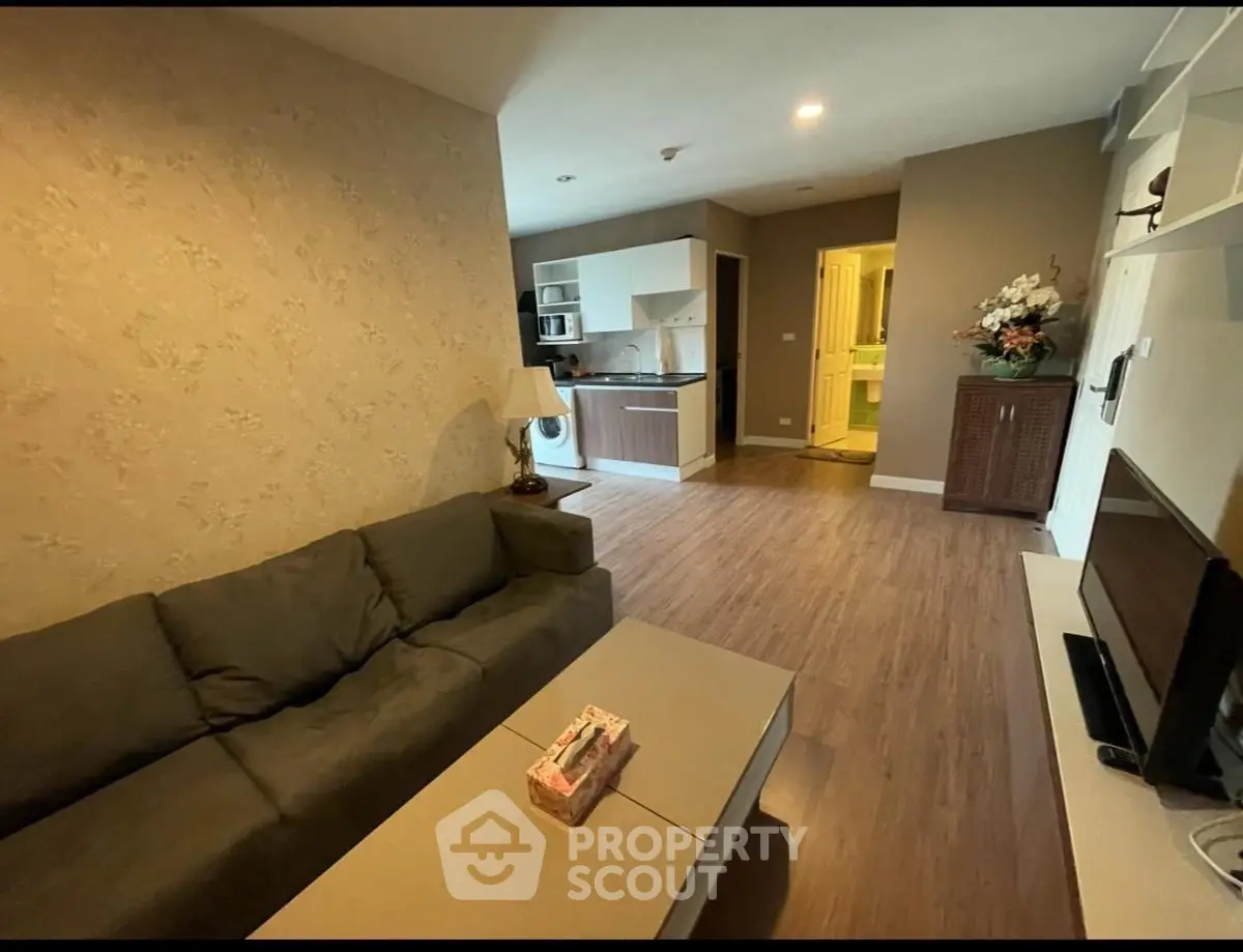 Spacious living room with modern kitchen and cozy sofa in open layout apartment.