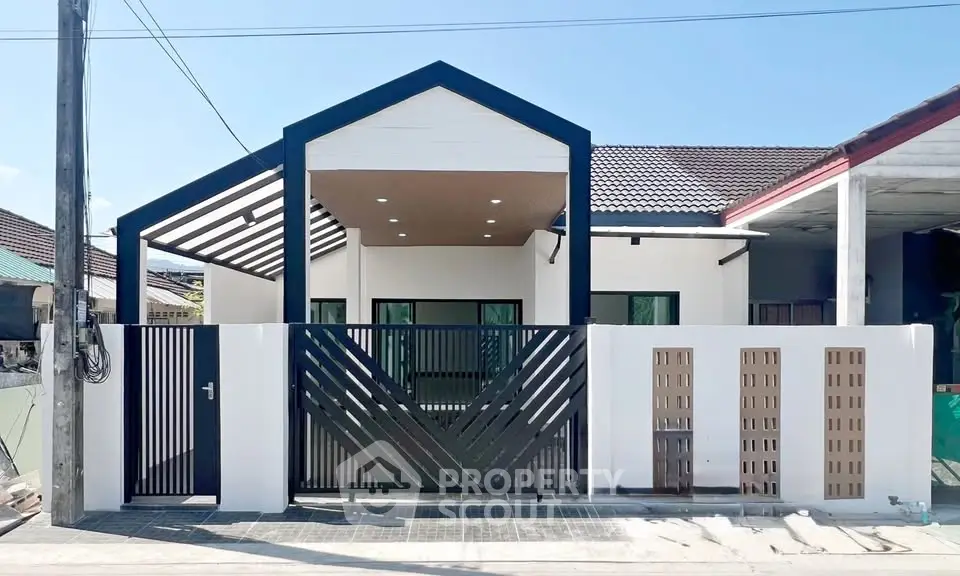 Modern single-story house with unique geometric facade and gated entrance.