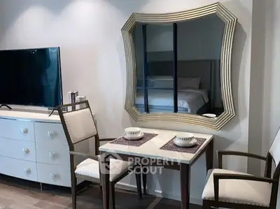 Chic modern bedroom with stylish mirror and cozy dining setup.