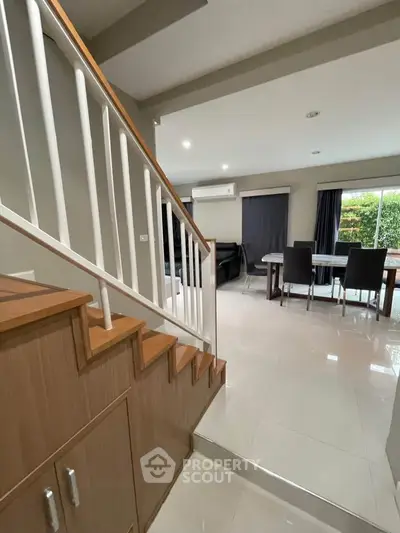 Modern open-plan living room with dining area and staircase