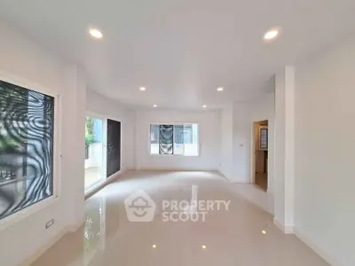 Spacious modern living room with large windows and glossy floors