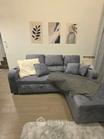 Stylish living room with modern gray sectional sofa and chic wall art