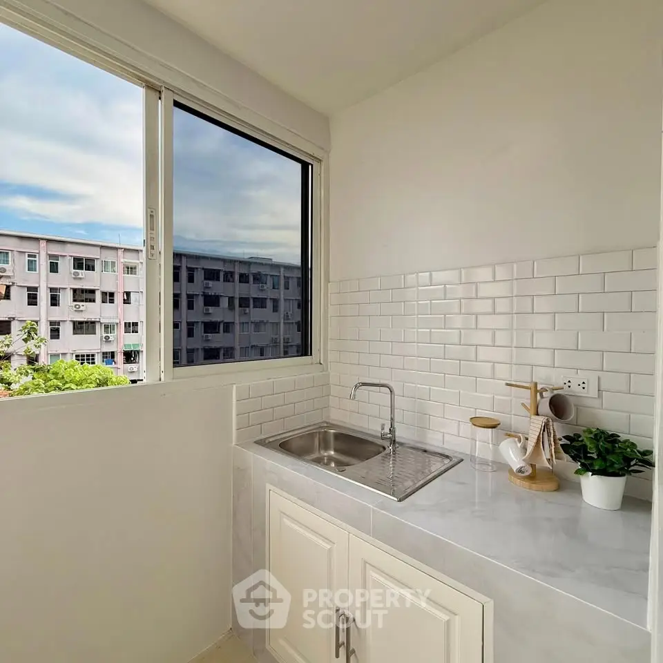 Bright kitchen with white subway tiles and large window view