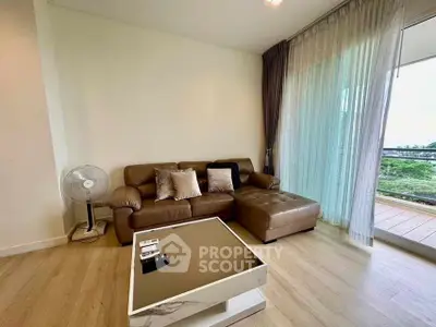 Modern living room with brown leather sofa and balcony view