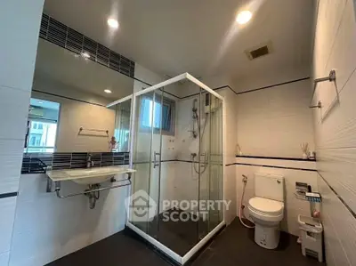 Modern bathroom with glass shower and sleek fixtures in a contemporary home.