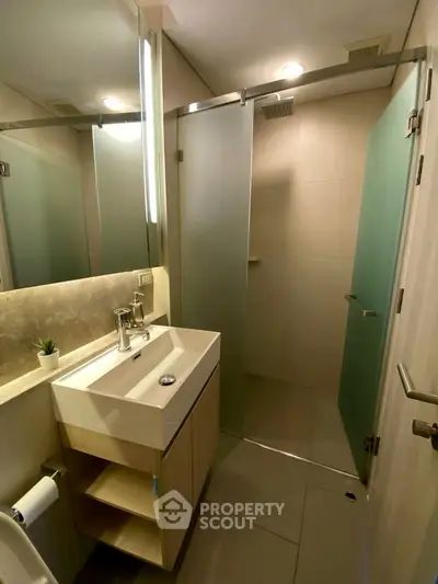 Modern bathroom with sleek design, featuring a glass shower enclosure and stylish vanity.