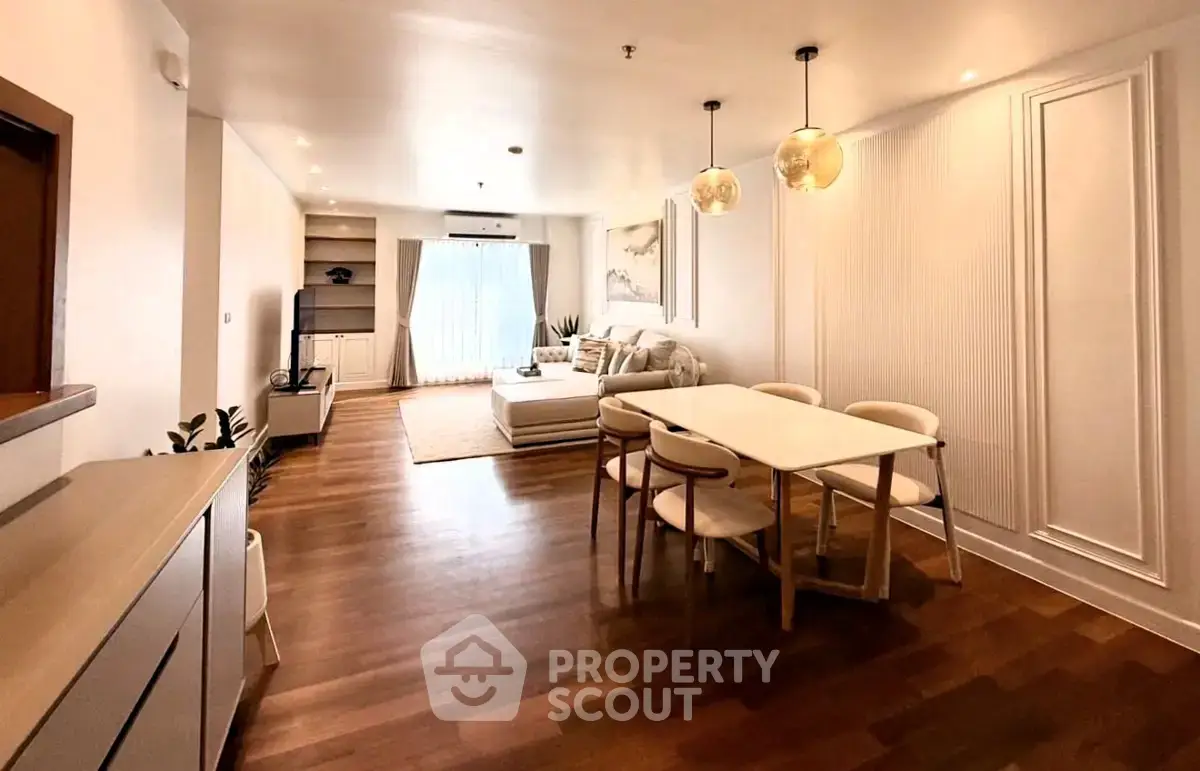 Spacious open-plan living and dining area with modern decor and wooden flooring.