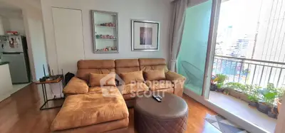 Cozy living room with plush sofa and balcony view in modern apartment