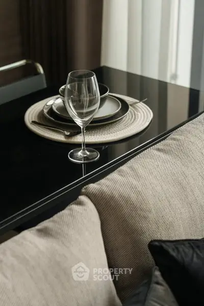 Elegant dining setup with wine glass on modern table in stylish living area.