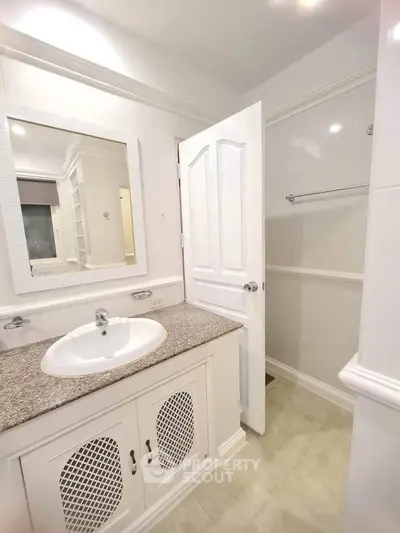 Elegant bathroom with granite countertop and white cabinetry