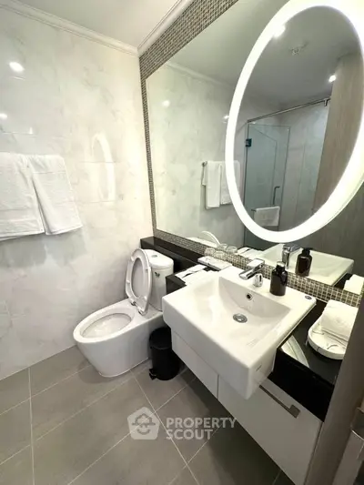 Modern bathroom with elegant fixtures and large mirror, perfect for a luxurious home.