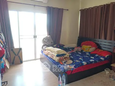 Cozy bedroom with large window and playful bedding, ideal for a child's room.