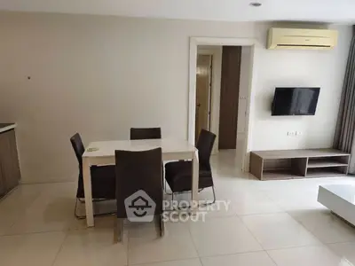 Modern living room with dining area and wall-mounted TV in a stylish apartment.
