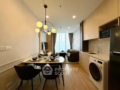 Modern open-plan living room with dining area and kitchen, featuring stylish lighting and cozy seating.
