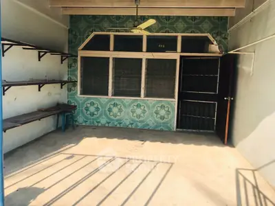 Charming enclosed balcony with vintage tiles and ample shelving, perfect for relaxation or storage.