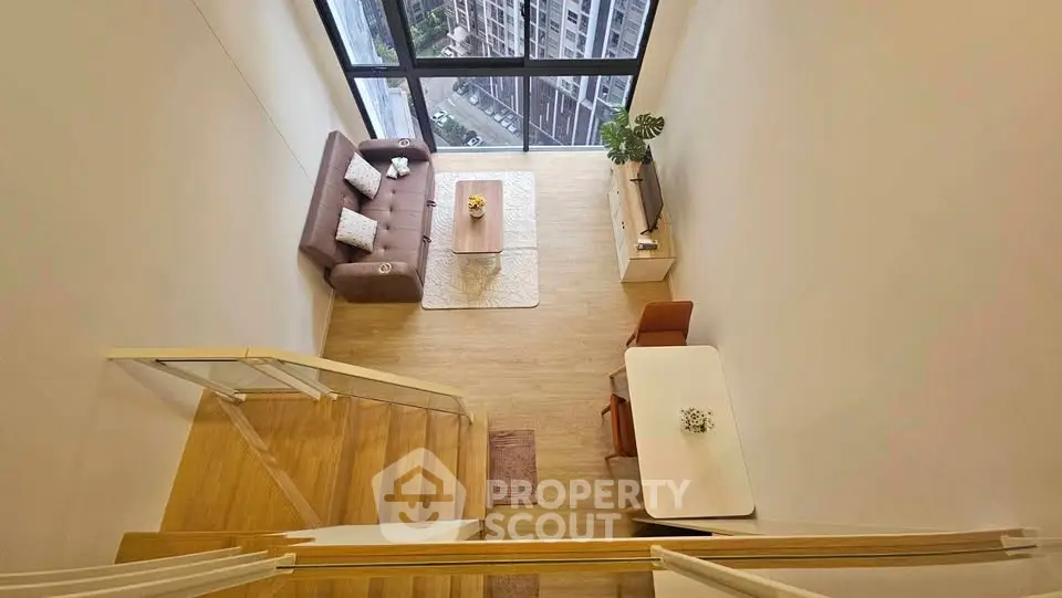 Modern loft apartment with high ceilings and large windows offering stunning city views.