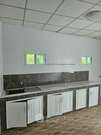 Spacious kitchen with modern design and ample storage in a bright, airy setting.