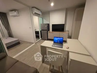 Modern studio apartment with sleek design, featuring a compact kitchen and cozy living area.