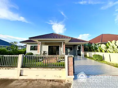 Charming single-story house with spacious driveway and lush garden in serene neighborhood.