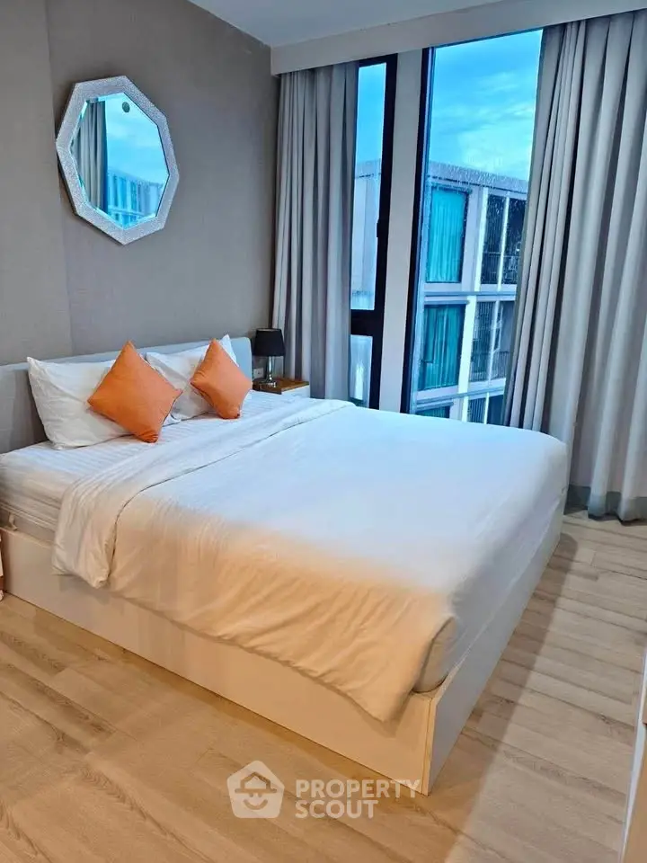 Modern bedroom with large window and stylish decor in a contemporary apartment.