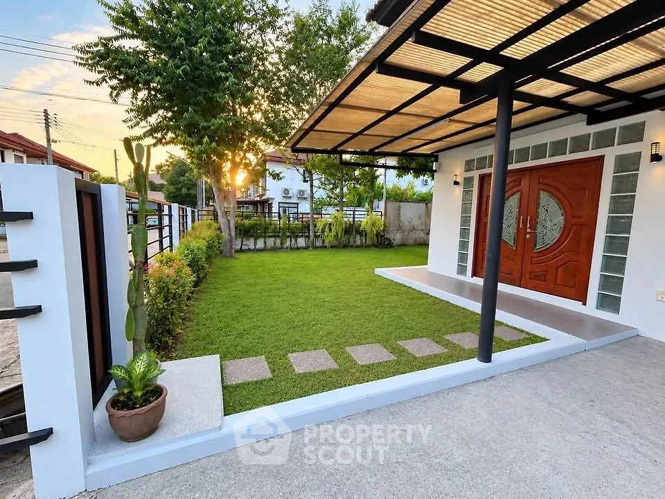 Charming modern home entrance with lush green lawn and stylish wooden door, perfect for serene living.