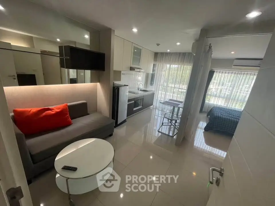 Modern open-plan living room with kitchen and bedroom in a stylish apartment.