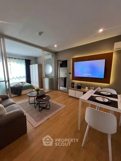 Modern living room with open layout and cozy bedroom, featuring stylish decor and natural light.