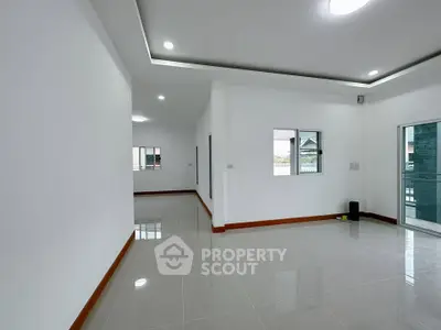 Spacious modern living room with sleek tile flooring and recessed lighting.