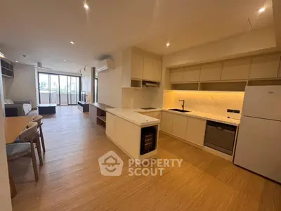 Spacious open-plan kitchen and living area with modern appliances and wooden flooring.