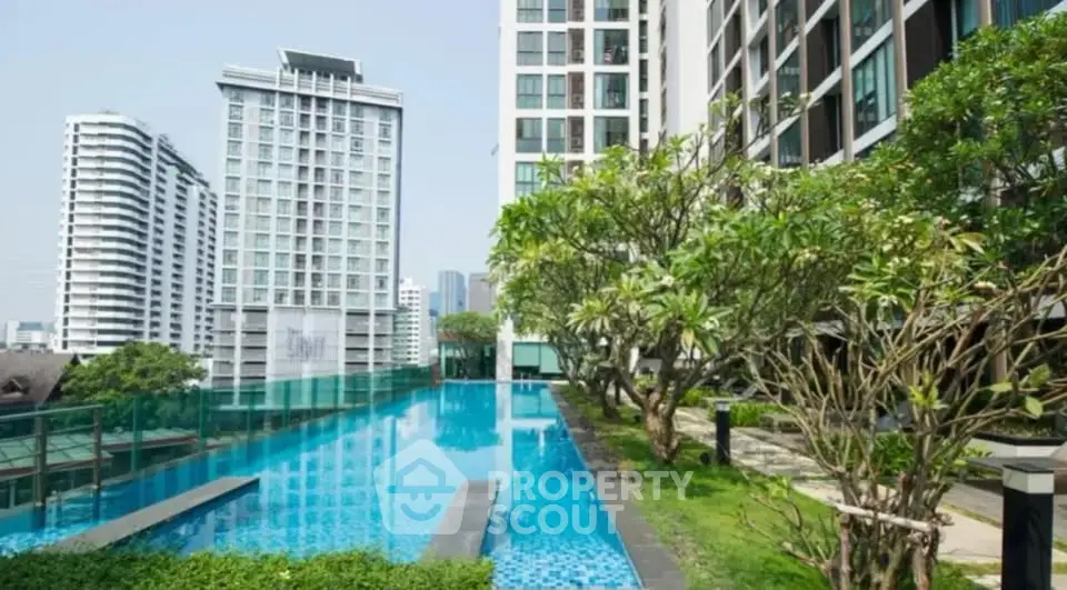 Luxurious condominium with stunning pool and lush greenery in urban setting.