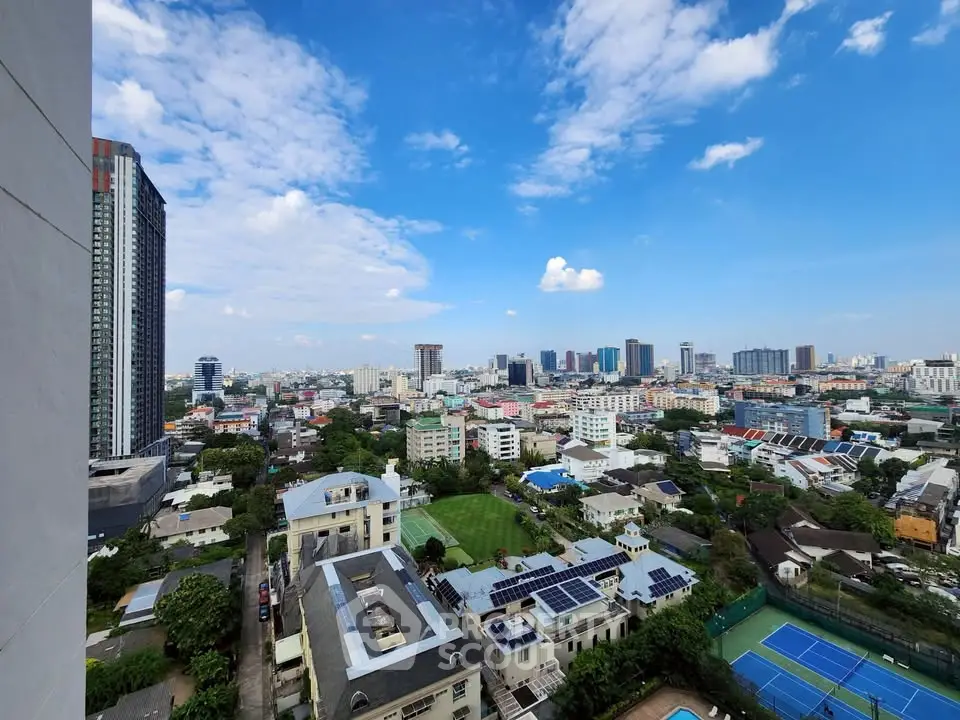 Stunning cityscape view from high-rise building showcasing urban skyline and lush greenery.