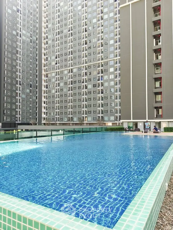 Luxurious high-rise apartment complex with stunning outdoor pool and modern architecture.