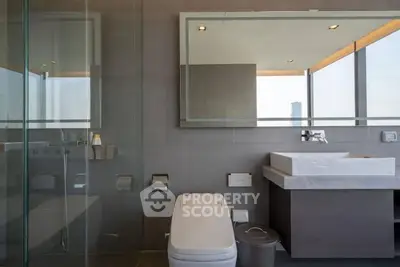 Modern bathroom with sleek fixtures and large mirror in luxury apartment.