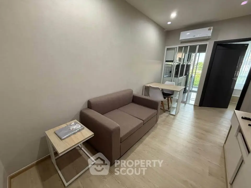 Modern living room with cozy sofa and sleek design, featuring air conditioning and natural light.