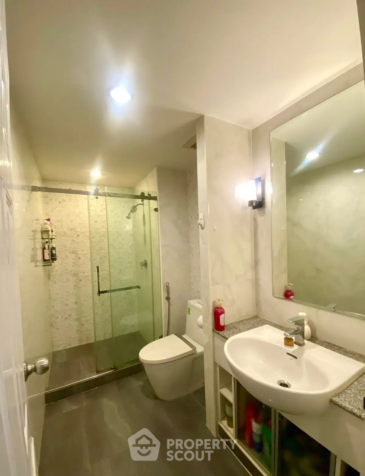 Modern bathroom with glass shower and sleek fixtures in a stylish home.