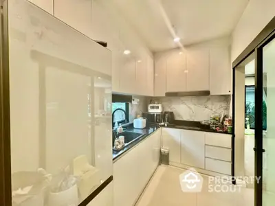 Modern kitchen with sleek white cabinets and marble backsplash