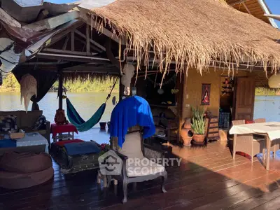 Charming open-air living space with rustic decor and serene waterfront view.