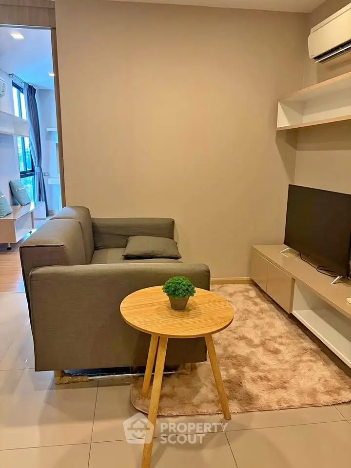 Cozy living room with modern sofa, TV, and air conditioning in a stylish apartment.