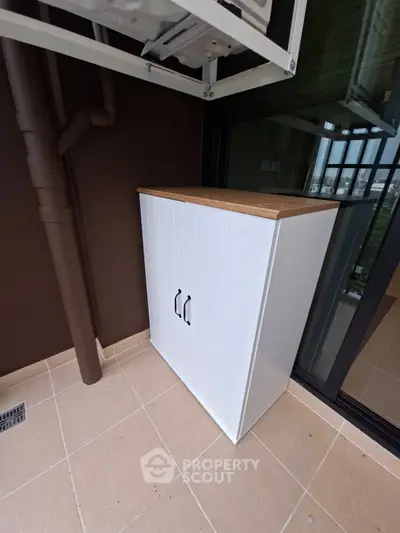 Modern balcony with sleek white storage cabinet and tiled flooring