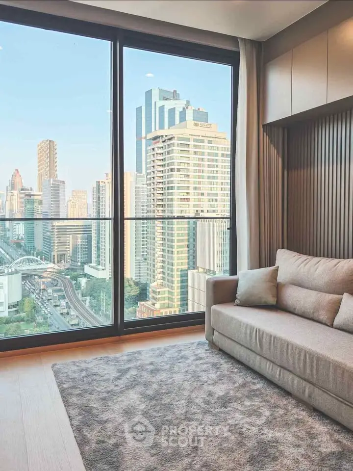 Modern living room with stunning city view through large windows, featuring a cozy sofa and elegant decor.