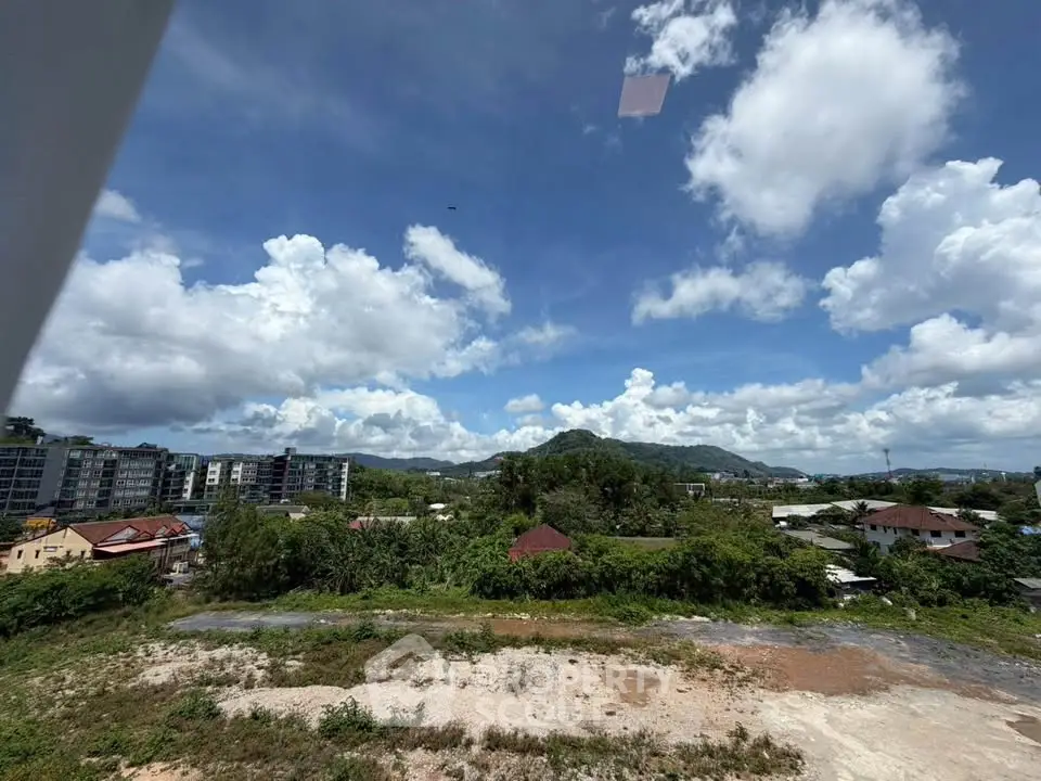 Scenic view of lush greenery and distant mountains from a high vantage point, ideal for real estate development.