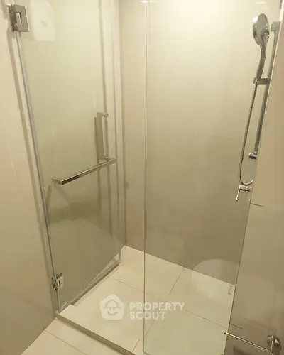 Modern bathroom with glass shower enclosure and sleek fixtures.
